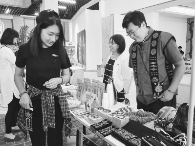 圖為臺灣屏東的創客Taunpake(右)帶來的手作作品,吸引了參觀者的目光。