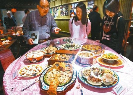 “奇石宴”搜藏家徐俊義(左)搜集瑪瑙、花崗巖各種石頭,拼成滿漢全席各式菜肴。來源:臺灣《聯合報》