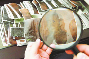 圖片說明:劉先生將保險柜內的現金灰燼一張張分開,并粘貼到白紙上