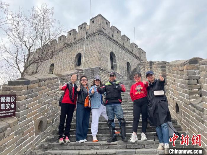 陳文仁在長(zhǎng)城與游客合影。 受訪者供圖