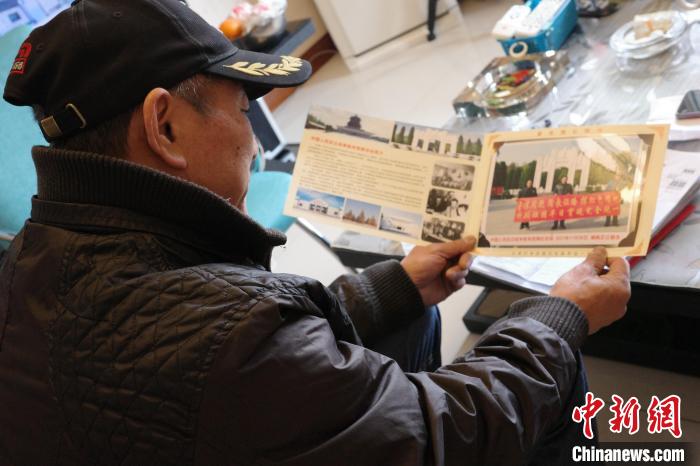 陳文仁拿出相冊(cè),講述騎行故事。 王鵬 攝